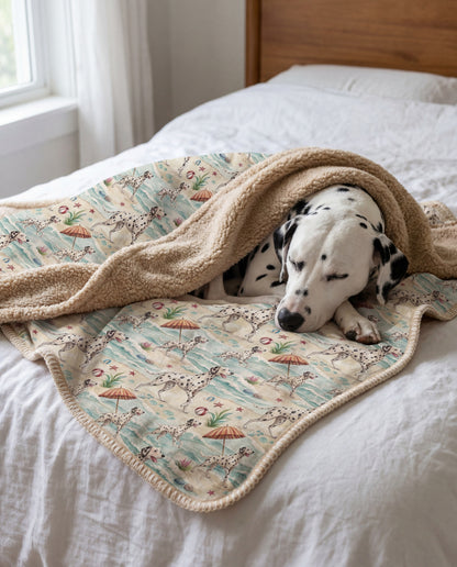 white Dalmatian with black spots curled asleep in a Dalmatian beach-day sherpa blanket on a bed