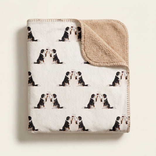 Top-down product photo of the Happy Hour Bernese Mountain Dog sherpa blanket folded on a cream background