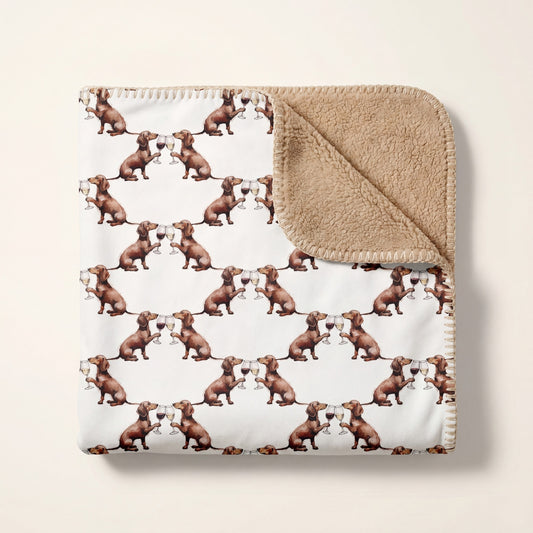 Top-down product photo of the Happy Hour Dachshund sherpa blanket folded on a cream background