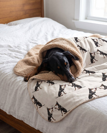 Doberman curled asleep in a Happy Hour Doberman sherpa blanket on a bed